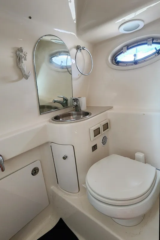 2012 Tiara Yachts 3100 Coronet bathroom with sink, mirror, and porthole window.