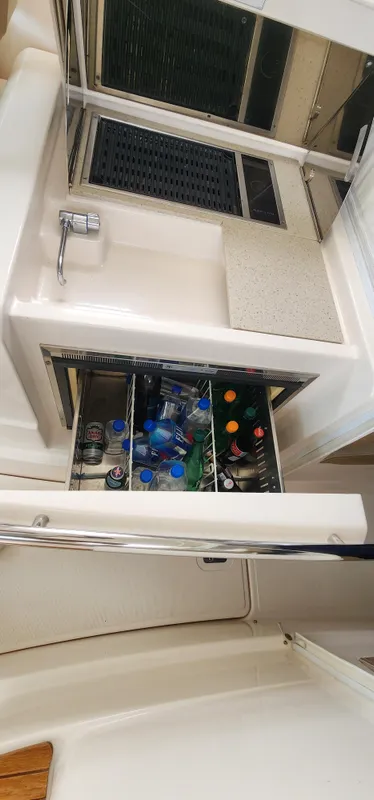 2012 Tiara Yachts 3100 Coronet beverage storage with assorted drinks.