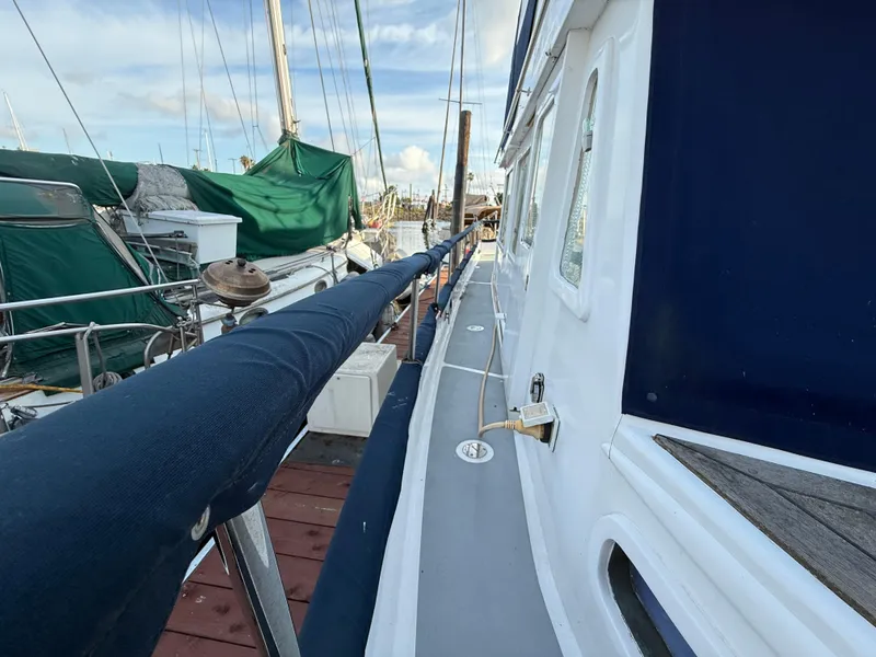 1978 C & L 37 sailboat docked, featuring a blue and white exterior with covered railings.