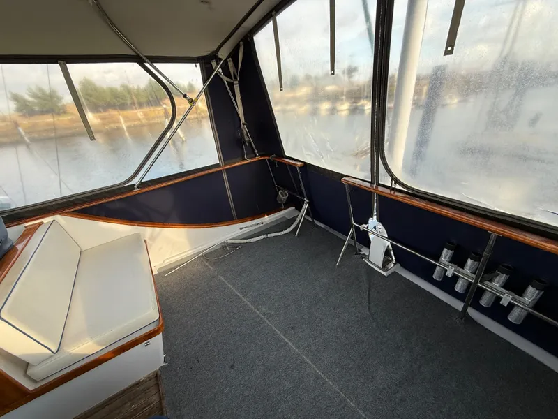 1978 C & L 37 boat interior with seating, windows, and carpeted floor.
