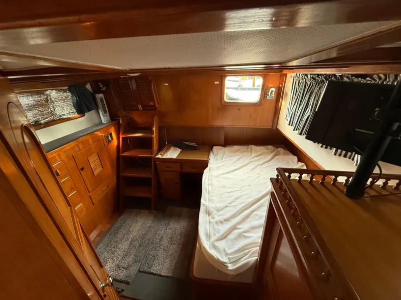 Cozy cabin interior of 1978 C & L 37 boat with bed, desk, and window.