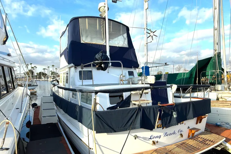 1978 C & L 37 boat docked in Long Beach marina, featuring blue canvas covers.