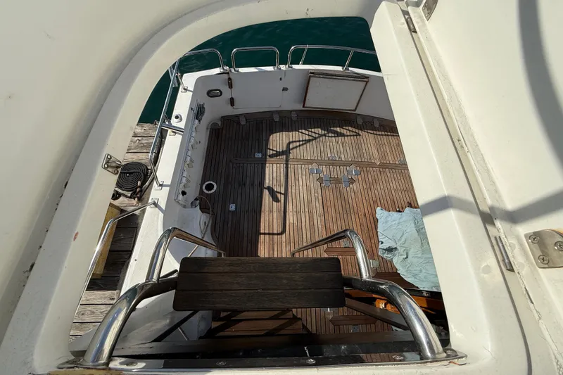 View of 1990 Mikelson 42 yacht deck with wooden flooring and metal railings.