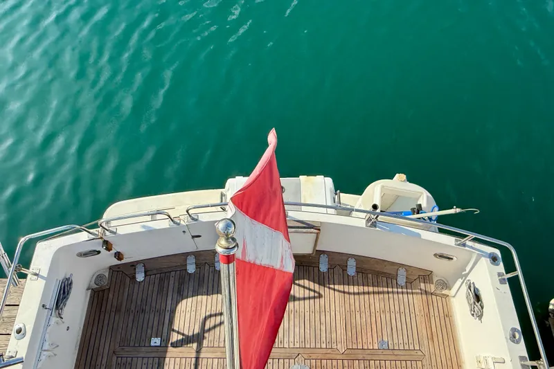 Aerial view of 1990 Mikelson 42 boat deck with red flag over turquoise water.