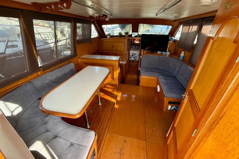 Interior of a 1990 Mikelson 42 yacht with wood paneling and seating area.