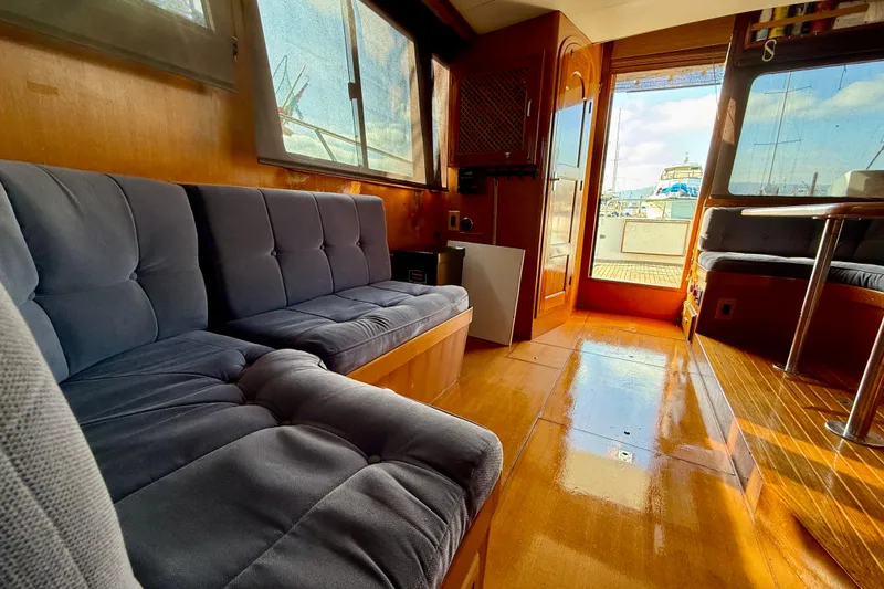 Interior of 1990 Mikelson 42 yacht with plush seating and wooden flooring.