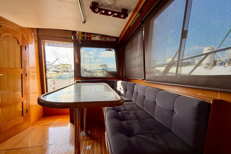 Interior of 1990 Mikelson 42 yacht with wooden finishes and cushioned seating.