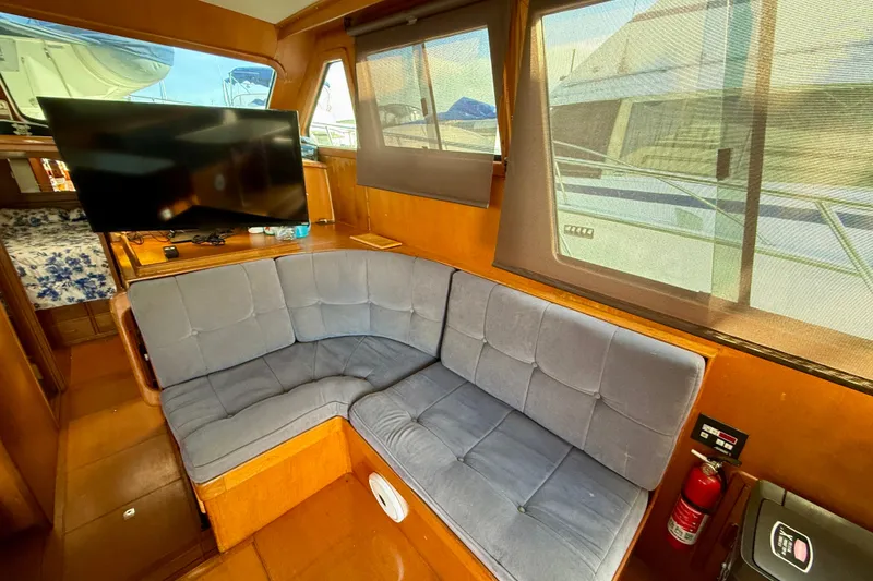 Interior of 1990 Mikelson 42 yacht with cozy seating and TV.