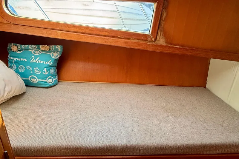 Cozy cabin interior of 1990 Mikelson 42 yacht with Cayman Islands pillow.