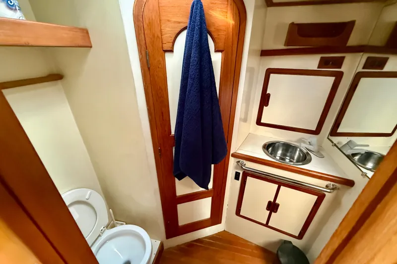 1990 Mikelson 42 yacht bathroom with wooden accents and compact design.