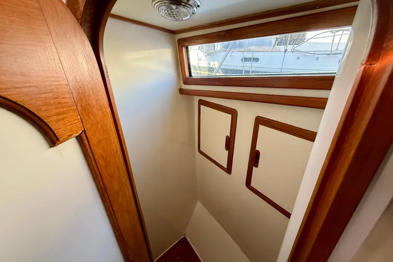 Interior of 1990 Mikelson 42 boat with wooden trim and storage cabinets.