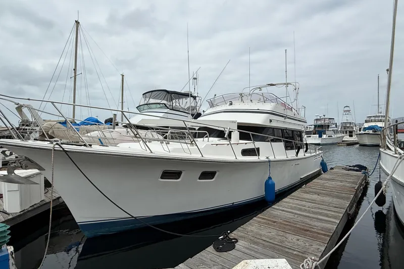 1990 Mikelson 42 yacht docked at marina under cloudy sky.