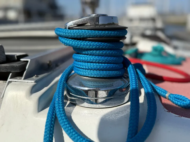 Blue rope wrapped around a winch on a 1989 Hunter 30 sailboat deck.