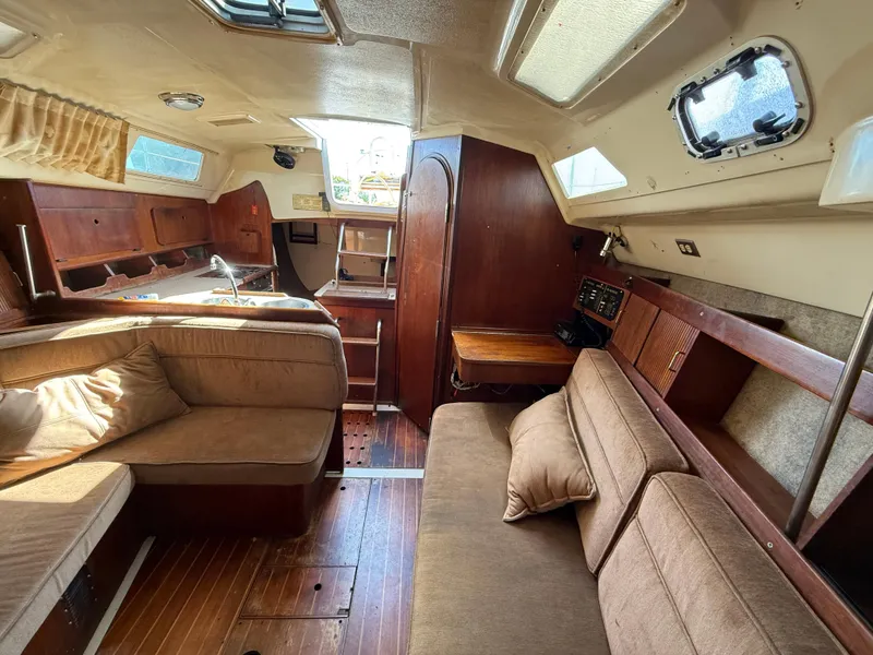 Interior of 1989 Hunter 30 sailboat with cozy seating and wooden finishes.