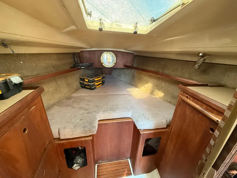 Cozy cabin interior of 1989 Hunter 30 sailboat with wooden finish and storage.