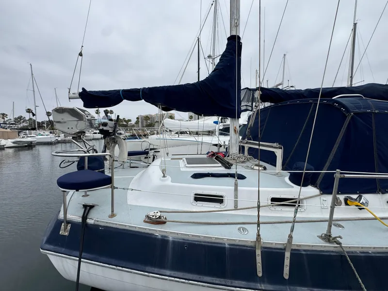1981 Morgan 416 Out Island sailboat docked in a marina, featuring blue covers and rigging.