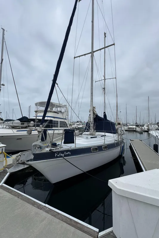 1981 Morgan 416 Out Island sailboat docked in a marina under cloudy skies.