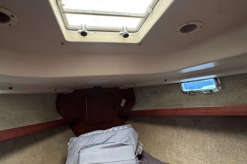 Interior cabin of a 1981 Morgan 416 Out Island sailboat, featuring a skylight and cozy bedding.