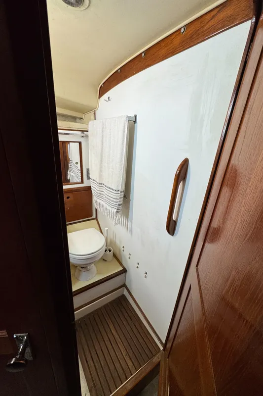 1981 Morgan 416 Out Island yacht bathroom with wooden accents and towel rack.