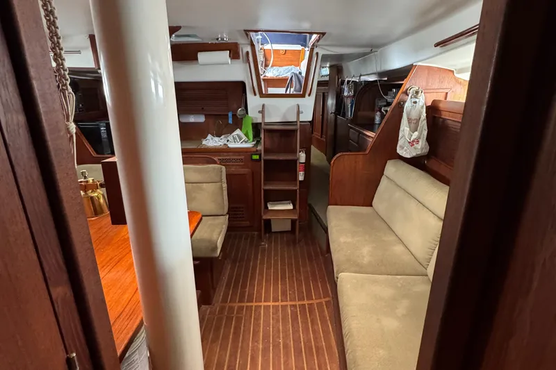 Interior of 1981 Morgan 416 Out Island sailboat, featuring cozy seating and wooden finishes.