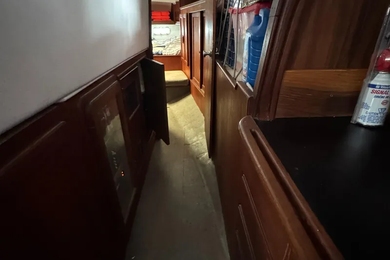 Narrow hallway inside 1981 Morgan 416 Out Island sailboat, featuring wooden cabinetry and storage.