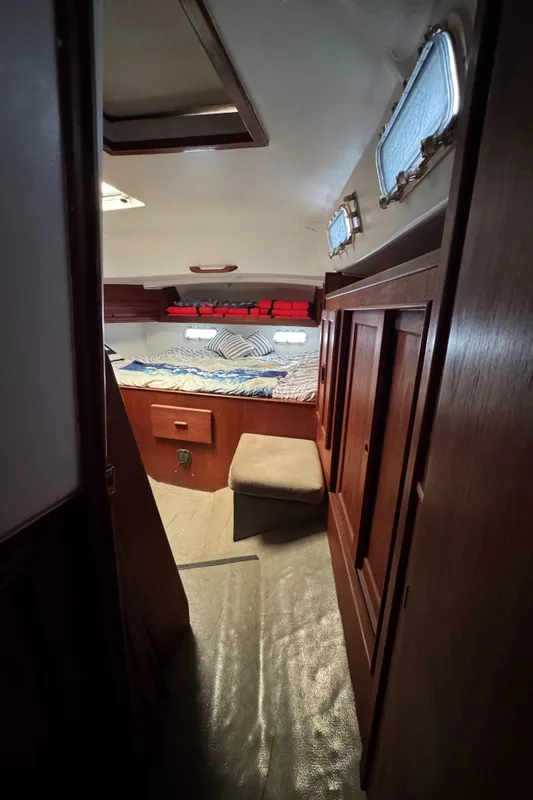 1981 Morgan 416 Out Island cabin interior with cozy bed and wooden furnishings.