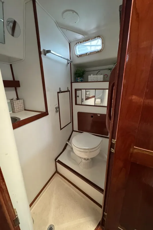 1981 Morgan 416 Out Island yacht bathroom with toilet, sink, and wooden accents.