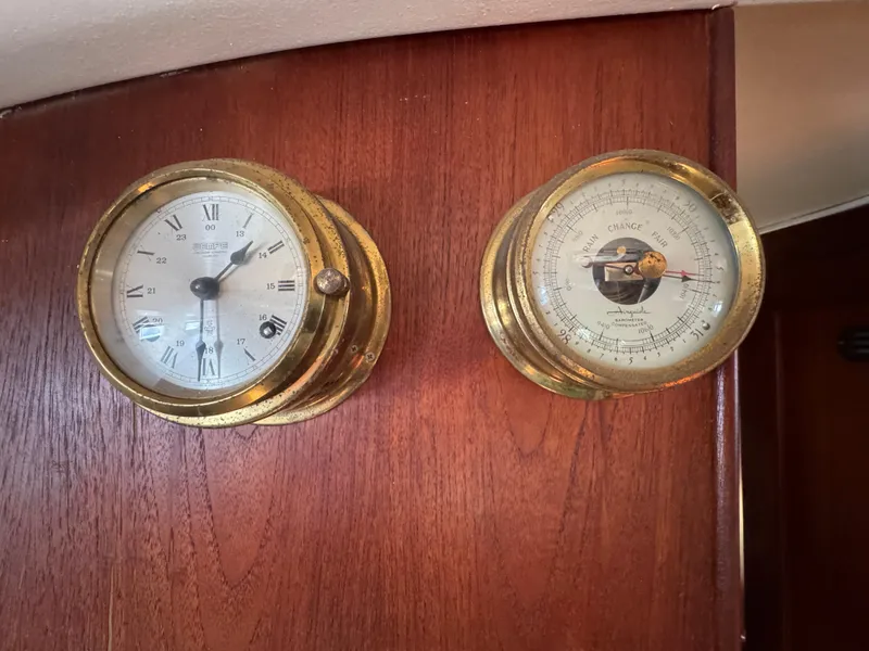 Brass clock and barometer on 1981 Morgan 416 Out Island yacht's wooden interior.