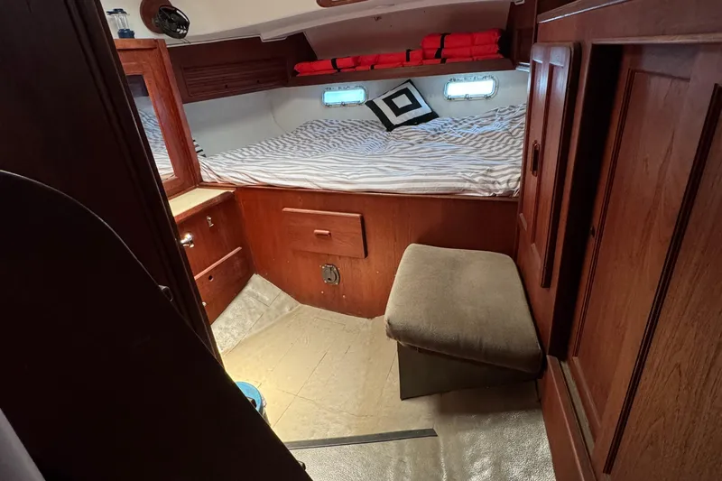 Cozy cabin interior of 1981 Morgan 416 Out Island sailboat with bed and wooden cabinetry.