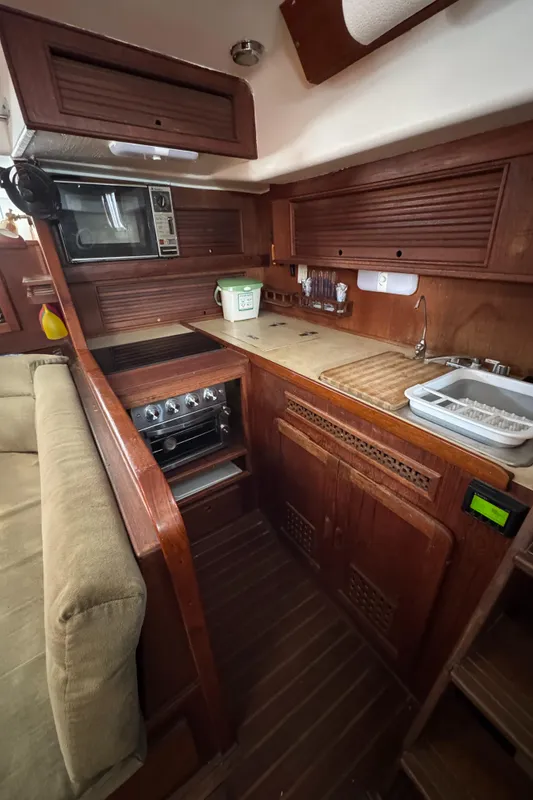 1981 Morgan 416 Out Island yacht interior kitchen with wooden cabinetry and modern appliances.