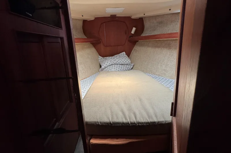 Cozy cabin interior of 1981 Morgan 416 Out Island sailboat with bed and wooden accents.