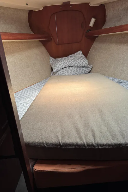 1981 Morgan 416 Out Island cabin interior with cozy bedding and wooden accents.