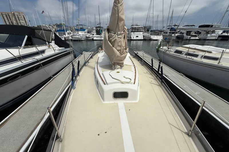 1957 Rhodes Bounty sailboat docked at a marina, surrounded by other boats.