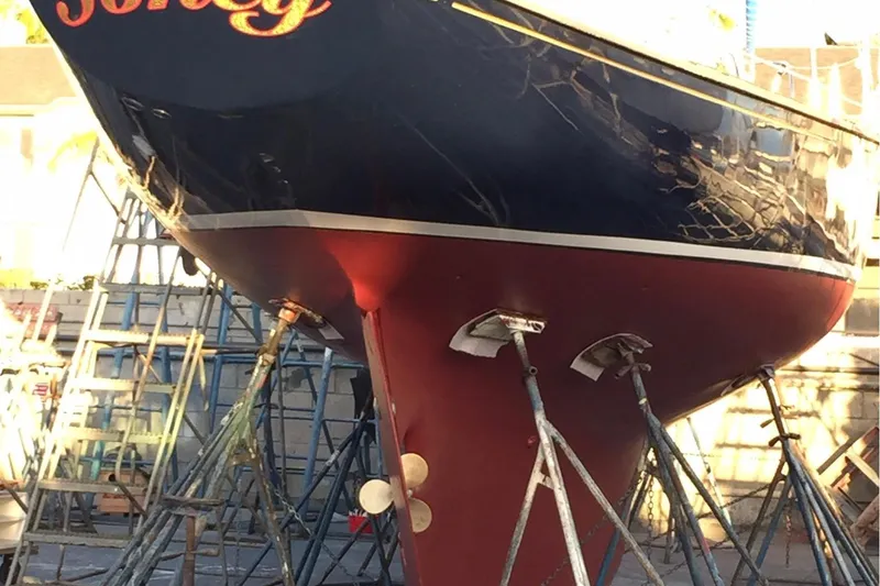 1957 Rhodes Bounty sailboat on stands, showcasing its hull and propeller.