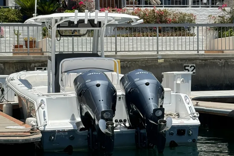 2021 Sea Hunt Gamefish 30 Coffin Box boat docked with dual outboard engines.
