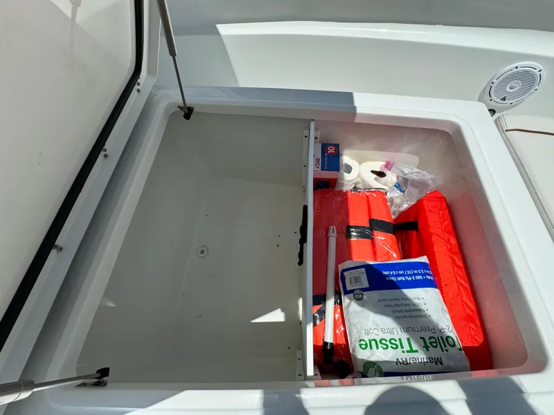 2021 Sea Hunt Gamefish 30 Coffin Box with storage items, including life jackets and tissue.
