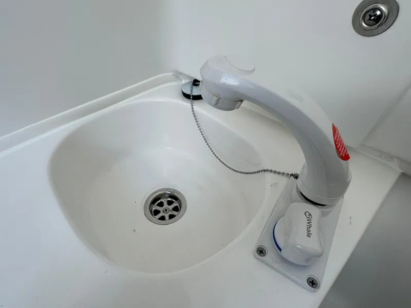 White sink with faucet on a 2021 Sea Hunt Gamefish 30 Coffin Box boat.
