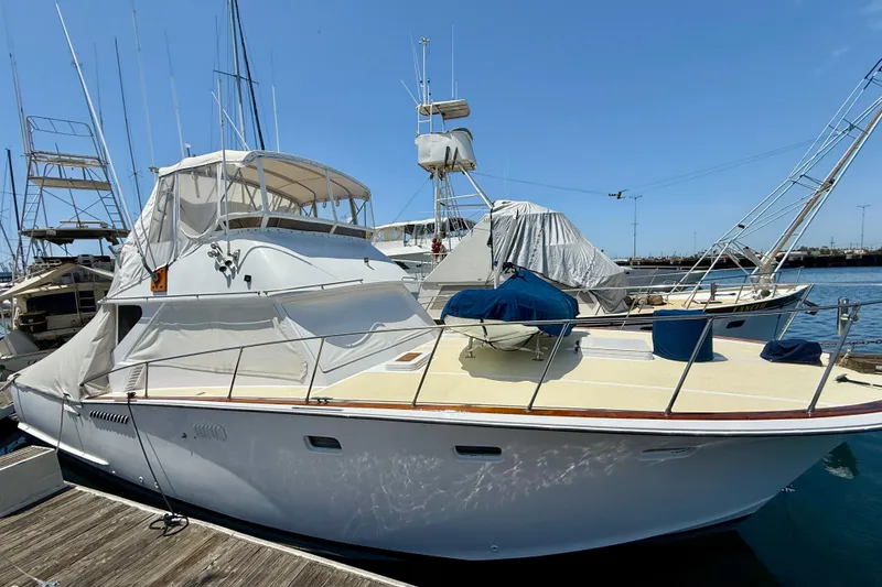 1971 Pacifica 44 Convertible yacht docked at marina under clear blue sky.