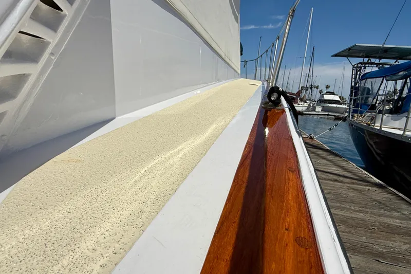 1971 Pacifica 44 Convertible yacht docked, showcasing polished wood and textured deck surface.