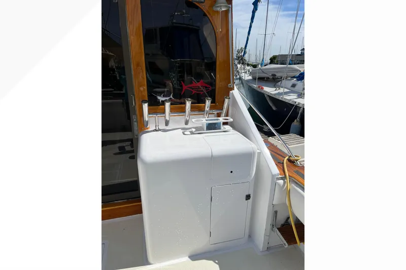 1971 Pacifica 44 Convertible yacht deck with fishing rod holders and storage compartment.