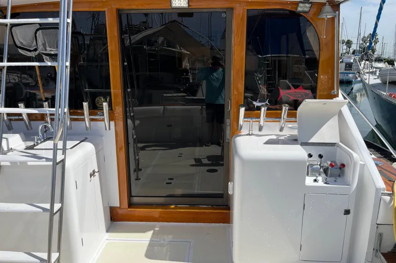 1971 Pacifica 44 Convertible yacht deck with fishing equipment and ladder in marina.