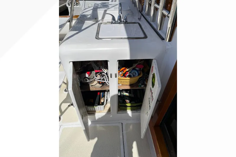 Open cabinet with tools and supplies on a 1971 Pacifica 44 Convertible boat.