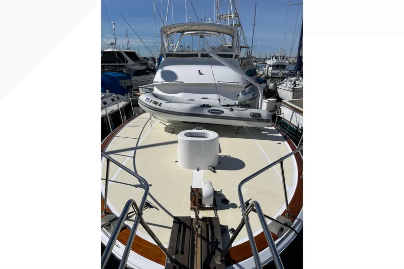 1971 Pacifica 44 Convertible yacht docked, featuring spacious deck and inflatable boat.