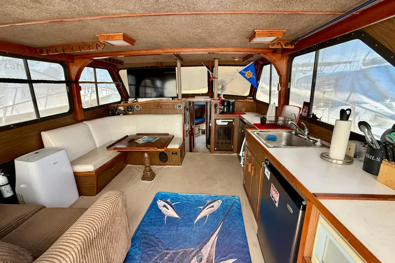 Interior of a 1971 Pacifica 44 Convertible boat with cozy seating and kitchenette.