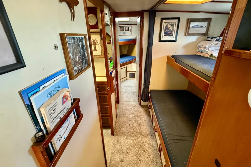 Interior of a 1971 Pacifica 44 Convertible boat with cozy bunks and nautical decor.