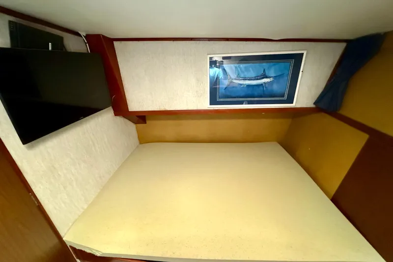 Interior cabin of 1971 Pacifica 44 Convertible with bed, TV, and fish artwork.