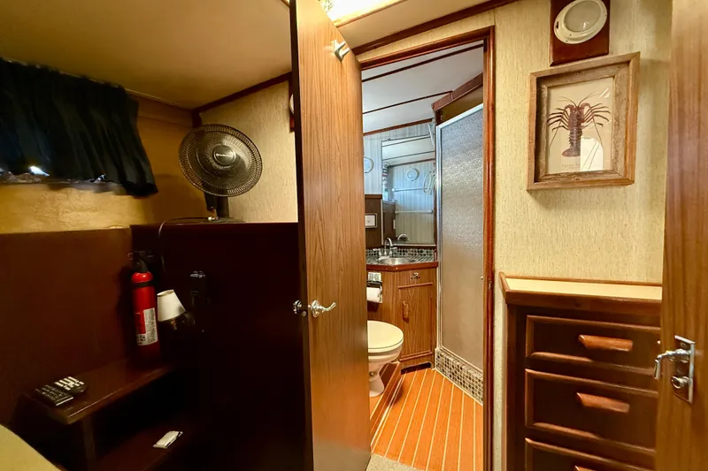 Interior of a 1971 Pacifica 44 Convertible yacht featuring a bathroom and wooden cabinetry.