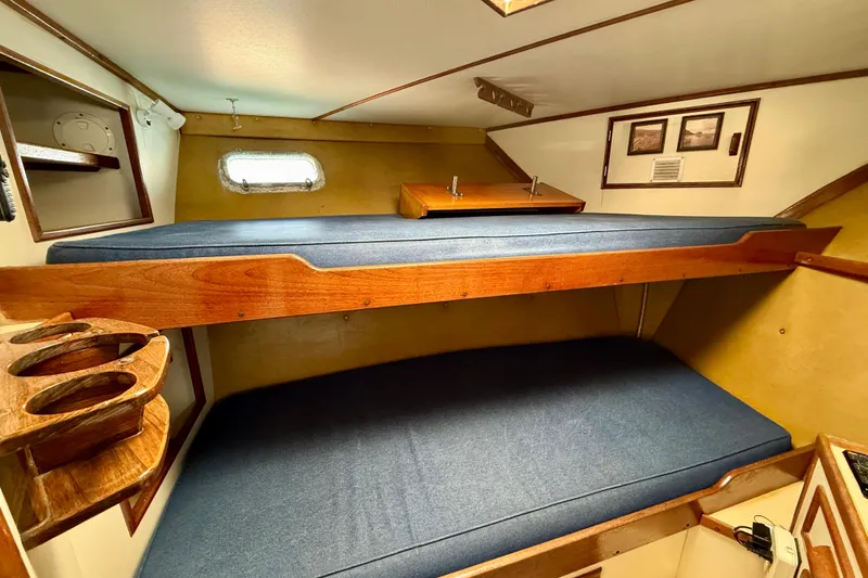1971 Pacifica 44 Convertible cabin with wooden bunk beds and nautical decor.