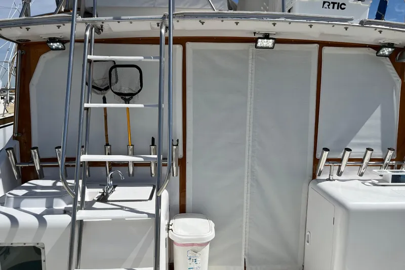1971 Pacifica 44 Convertible boat deck with ladder, fishing nets, and rod holders.