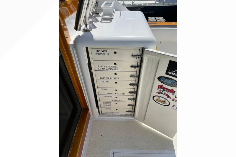 Fishing tackle storage on a 1971 Pacifica 44 Convertible boat, featuring labeled compartments.